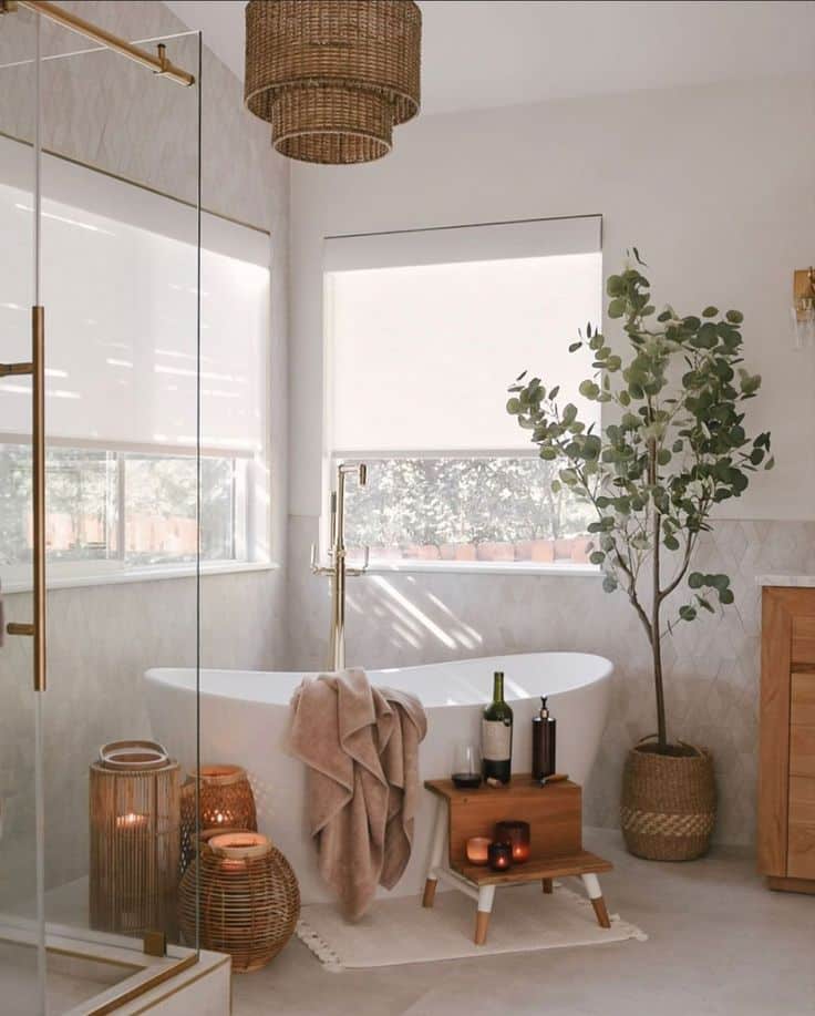 Minimalist bathroom with a freestanding tub, wooden accents, plants, and soft lighting for a cozy atmosphere.