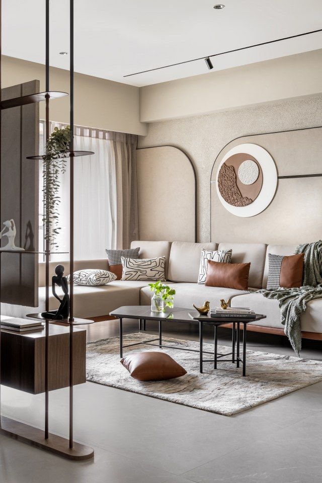 Modern living room with beige sofa, decorative pillows, abstract wall art, coffee table, and cozy decor.