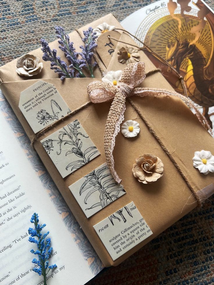 Beautifully wrapped brown gift with floral accents, lace bow, and vintage botanical illustrations, atop an open book.