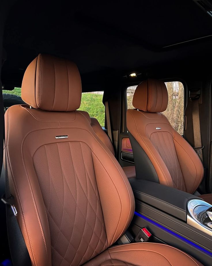 Luxury car interior with brown leather seats and sleek design elements, highlighting comfort and style.