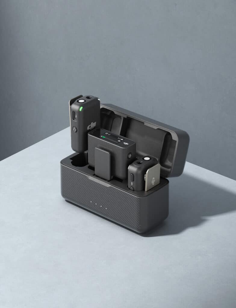Portable wireless microphone system with charging case on a gray surface.