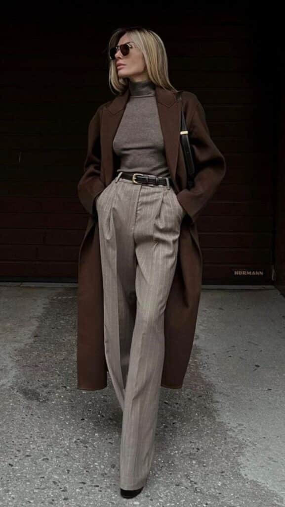 Woman in stylish brown coat and sunglasses showcasing fall fashion.