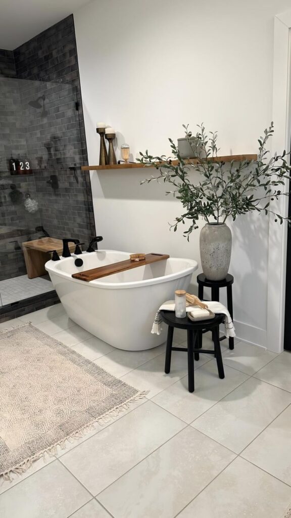Minimalist bathroom with a white freestanding tub, wood accents, and greenery for a modern spa-like atmosphere.