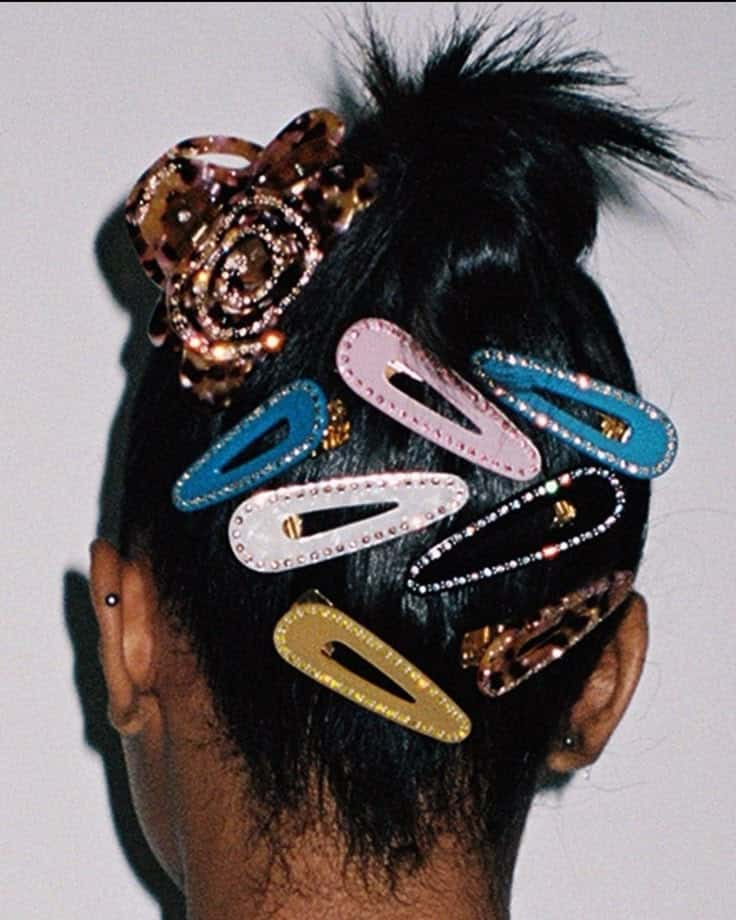 Colorful hair clips and a floral accessory in a stylish updo, showcasing vibrant and trendy hair fashion accessories.