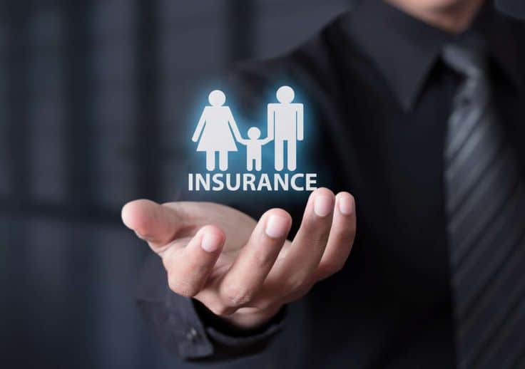 Businessman holding family insurance icon representing health and protection services.