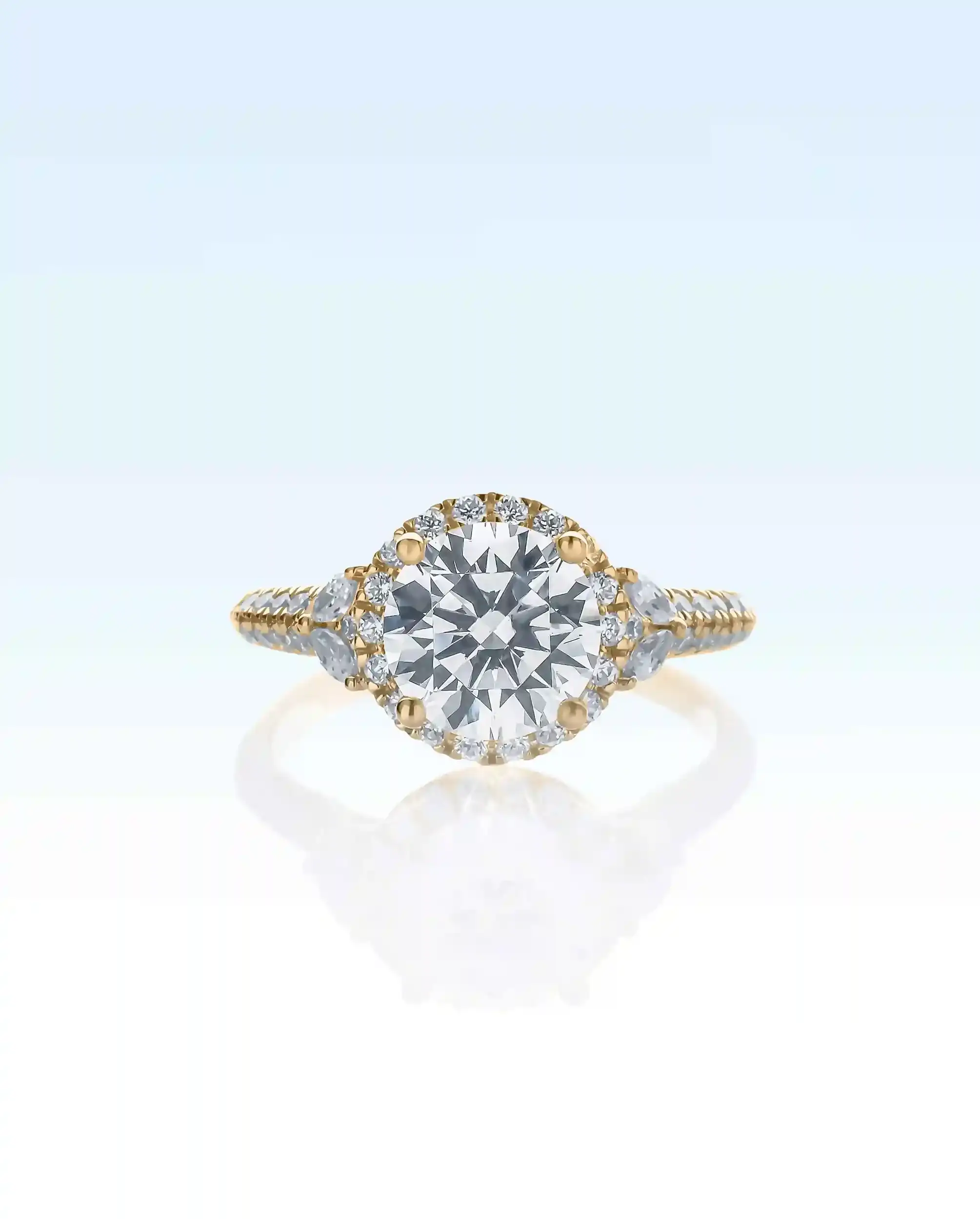 Gold engagement ring with a round diamond center stone, flanked by smaller diamonds on the band.