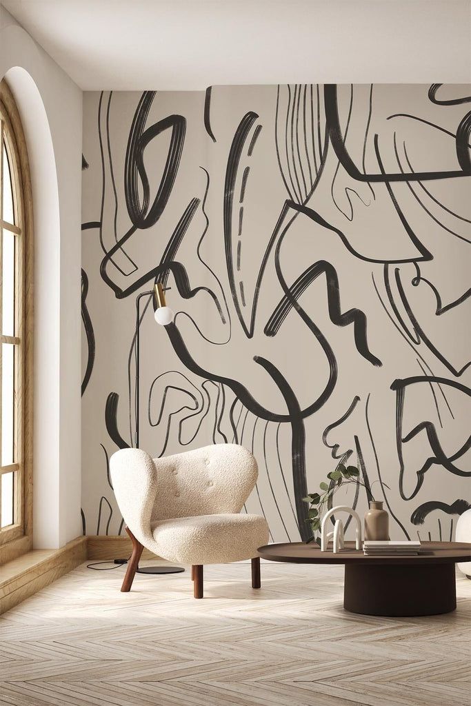 Modern armchair and table in a stylish room with abstract wall art and large window.