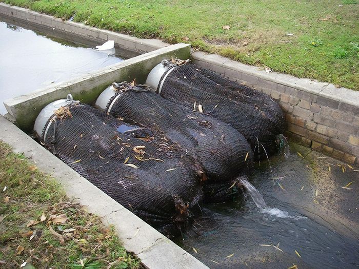 Stormwater drain with nets capturing debris, preventing pollution and improving water quality; environmental protection.