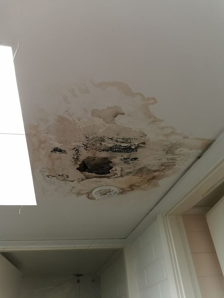 Damaged ceiling with large water stain and hole, indicating potential leak problem in a residential building.