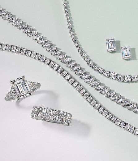 Elegant diamond jewelry set with rings, bracelets, and earrings on a light background. Perfect for luxury occasions.