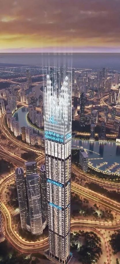 Tall skyscraper in a vibrant cityscape at dusk with illuminated windows and nearby winding roads.