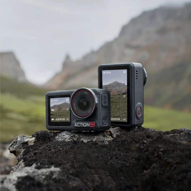Action cameras on a rocky surface in a scenic mountain landscape, capturing stunning outdoor adventure moments.