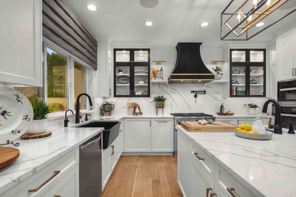 CopperSmith-SX10-Stainless-Steel-Range-Hood-001 Modern kitchen with white cabinets, marble countertops, black range hood, and stainless steel appliances. | Sky Rye Design Modern kitchen with white cabinets, marble countertops, black range hood, and stainless steel appliances.
