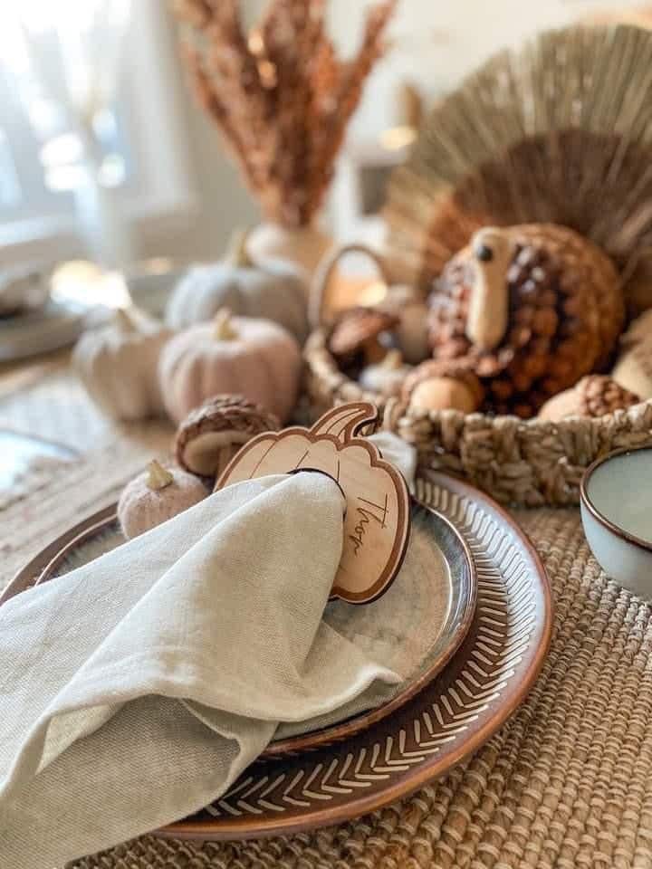 Autumn-themed table setting with pumpkin decor, plates, and napkin, perfect for Thanksgiving dining ambiance.
