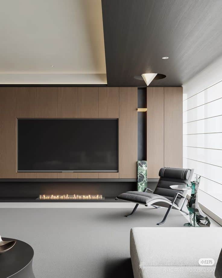 Modern living room interior with large TV, sleek fireplace, and stylish lounge chair for a minimalist design aesthetic.