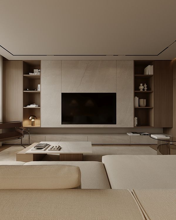 Modern living room with a minimalist design, featuring a large TV, beige sofa, and wooden shelves with decor items.