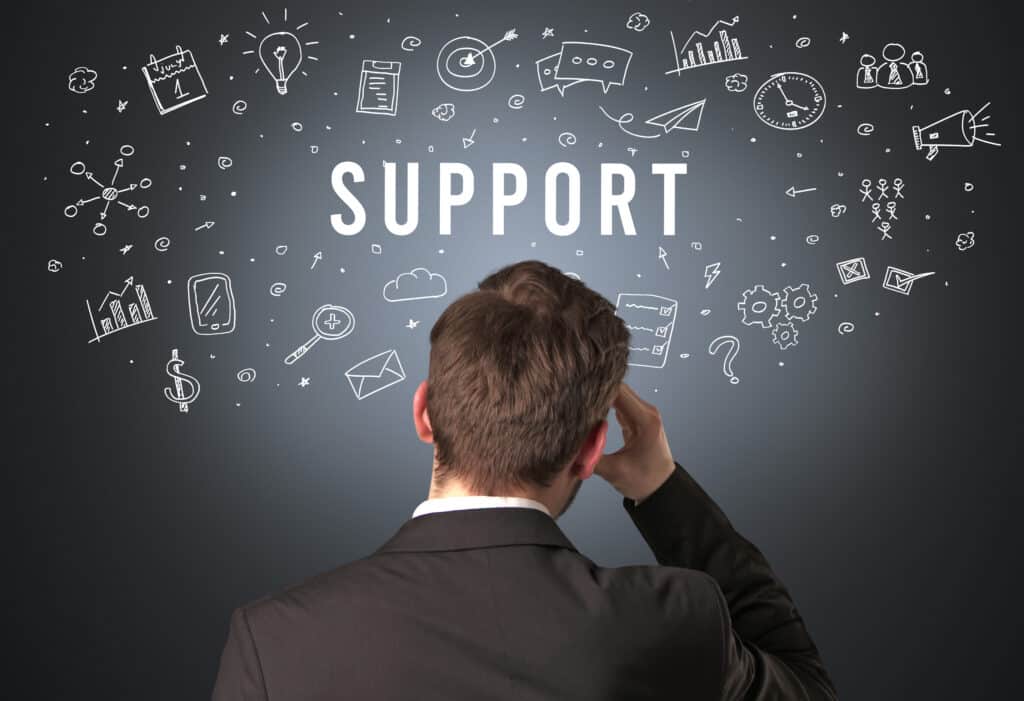 Person looking at digital icons and the word Support, symbolizing business and tech assistance.