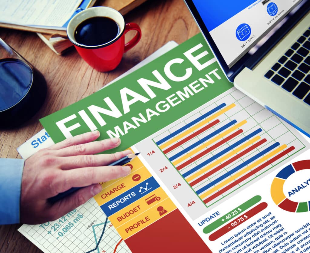 Finance management workspace with charts, graphs, and laptop on wooden desk. Business planning and analysis concept.