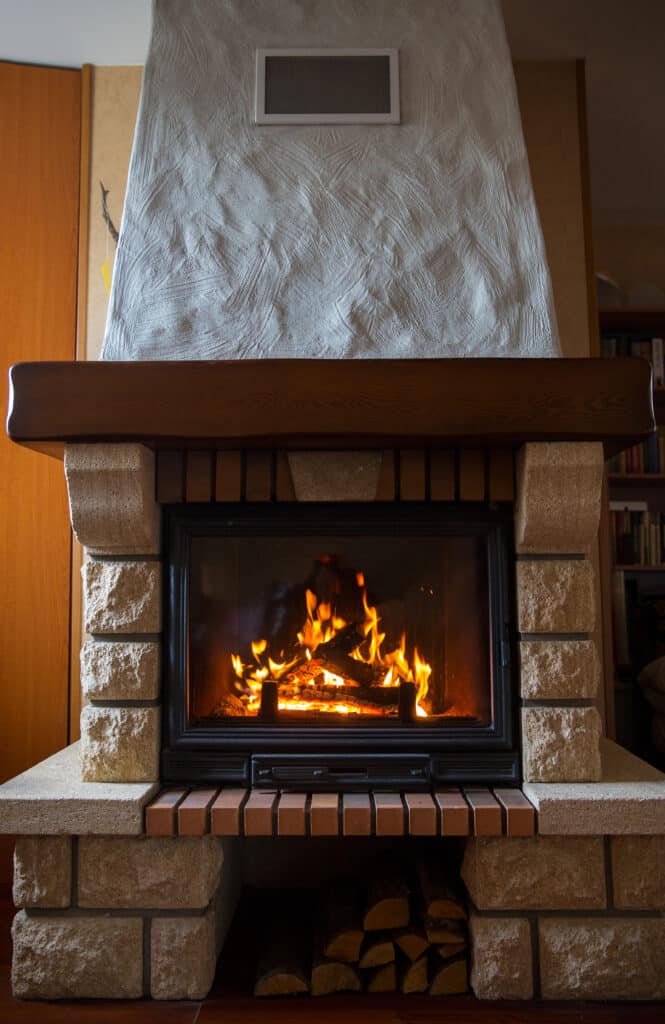 Cozy stone fireplace with crackling firewood, perfect for a warm and inviting home atmosphere.