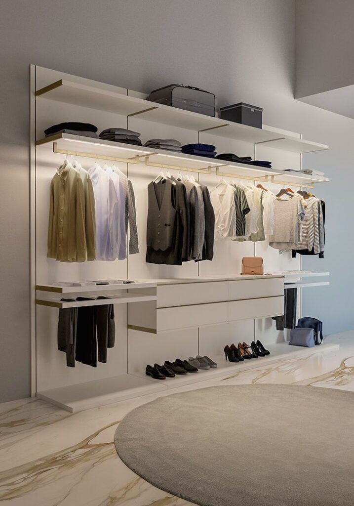 Modern closet with neatly organized clothes and shoes, featuring white shelves and a circular rug on marble floor.