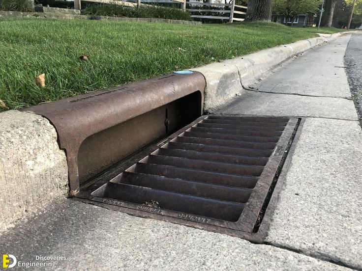 Storm drain on a street curb, designed for efficient water drainage and preventing urban flooding.