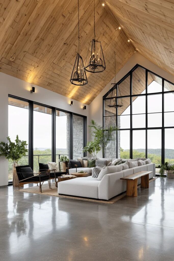 Spacious modern living room with high wooden ceiling, large windows, and elegant lighting over cozy seating area.