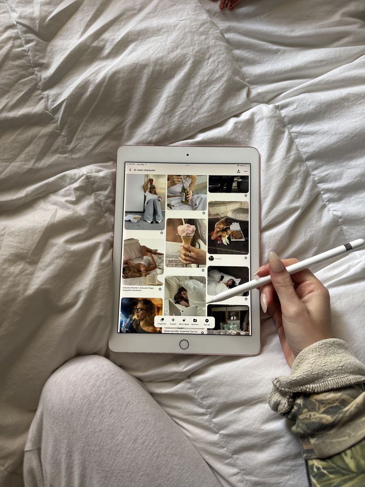 Elevate Your Online Image_ A Girls Guide to Aesthetic Perfection Tablet with stylus on bed displaying a Pinterest board titled main character, surrounded by cozy bedding. | Sky Rye Design Tablet with stylus on bed displaying a Pinterest board titled main character, surrounded by cozy bedding.