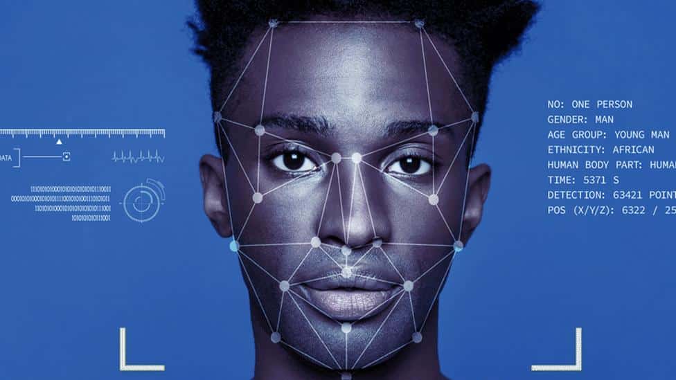 AI facial recognition technology scanning a man's face with data overlay on a blue background.