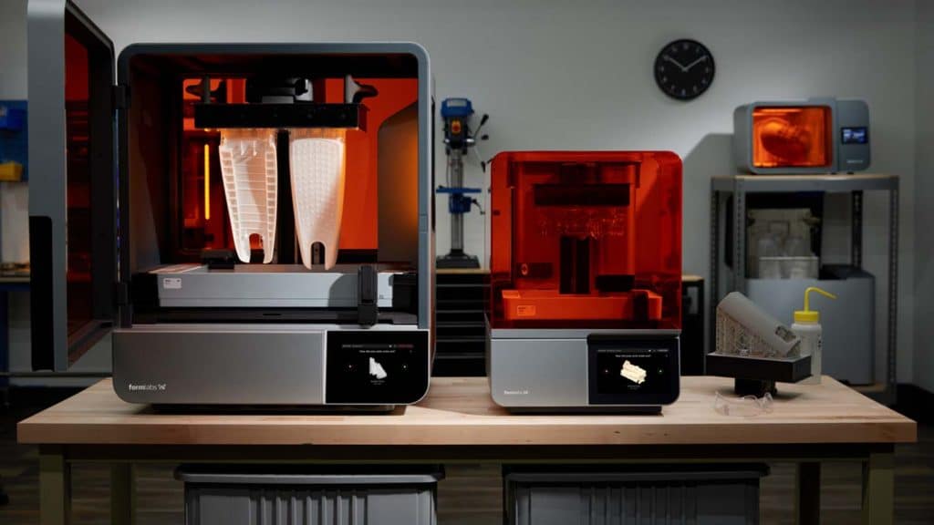 Two Formlabs 3D printers on a workbench in a workshop setting.