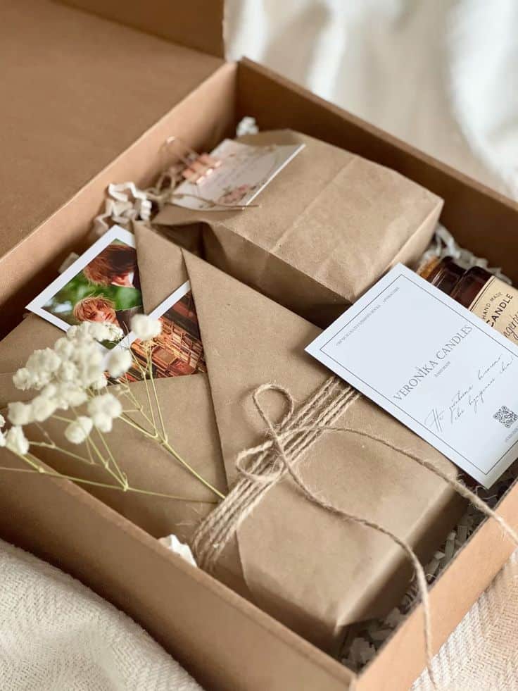 Gift box with brown paper packages, dried flowers, and personalized cards. Perfect for special occasions or celebrations.