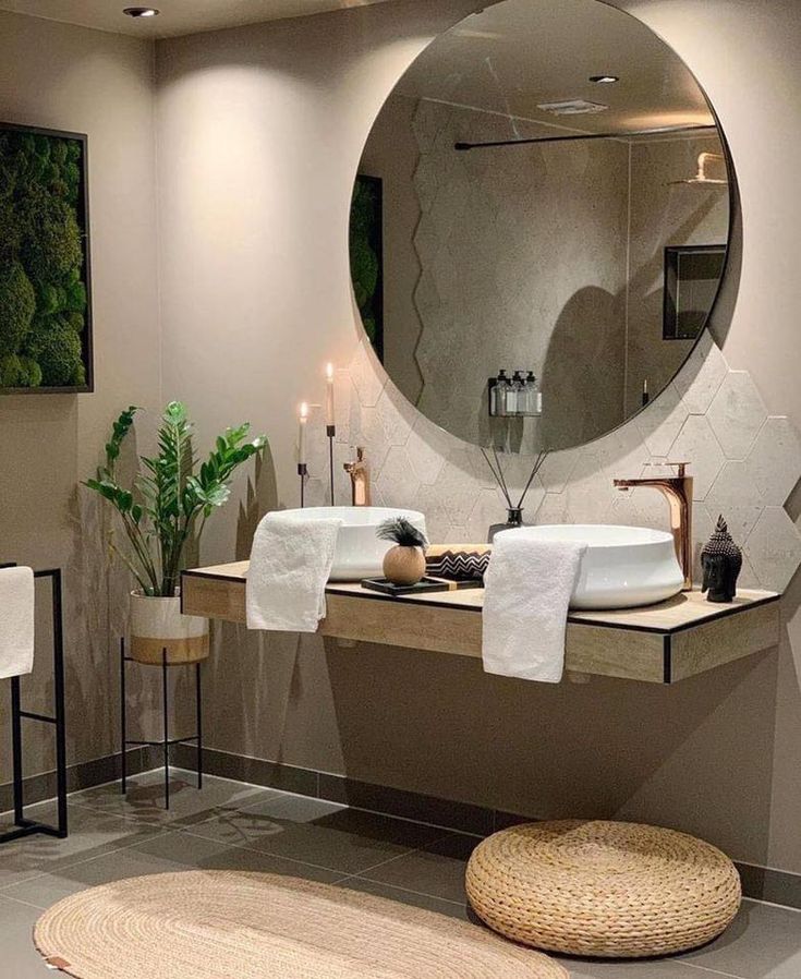 Modern bathroom with circular mirror, plants, and minimalist decor. Features a floating vanity and stylish accents.