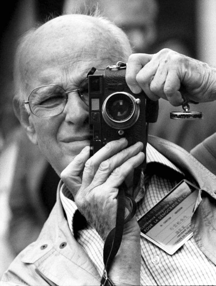 Henri Cartier-Bresson 布列松 Elderly man taking a photo with a vintage camera, wearing glasses and a jacket. | Sky Rye Design Elderly man taking a photo with a vintage camera, wearing glasses and a jacket.
