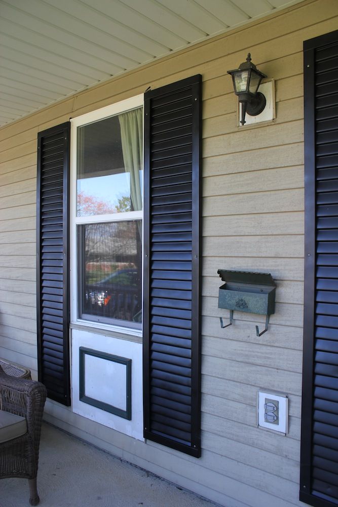 How To Repaint Shutters That Make You Shudder Front porch with black shutters, mailbox, and exterior light fixture on beige siding. | Sky Rye Design Front porch with black shutters, mailbox, and exterior light fixture on beige siding.