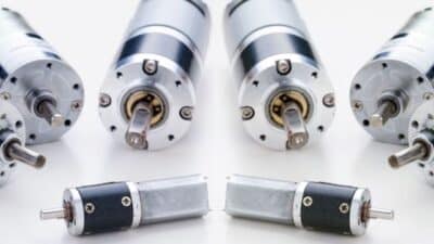 Close-up of multiple small electric motors aligned on a white surface.