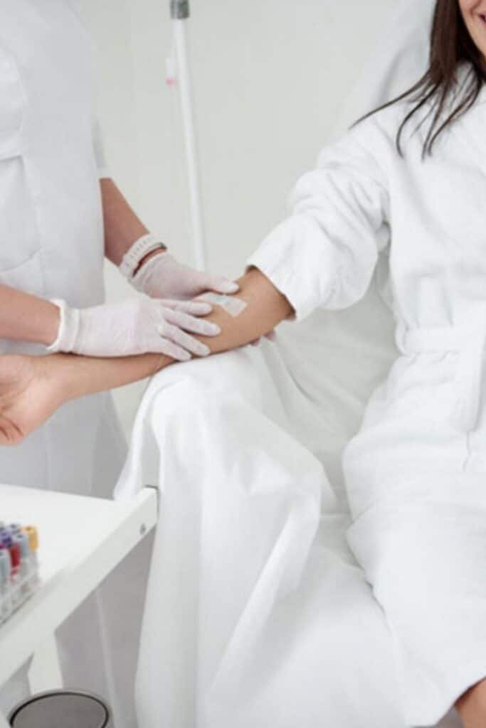 Healthcare professional applies bandage to patient's arm in a medical clinic setting.
