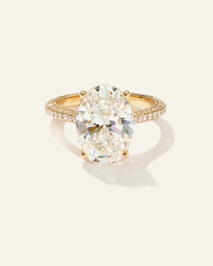 Lab Grown Diamond Oval Pave Cathedral Engagement Ring Oval diamond engagement ring with gold band accented by pave diamonds, elegant design on a light background. | Sky Rye Design Oval diamond engagement ring with gold band accented by pave diamonds, elegant design on a light background.