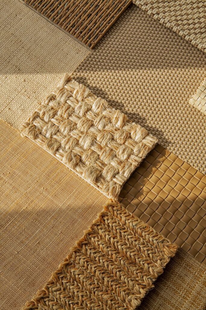 Various natural fiber mat samples with different textures and weaves in warm, earthy tones.