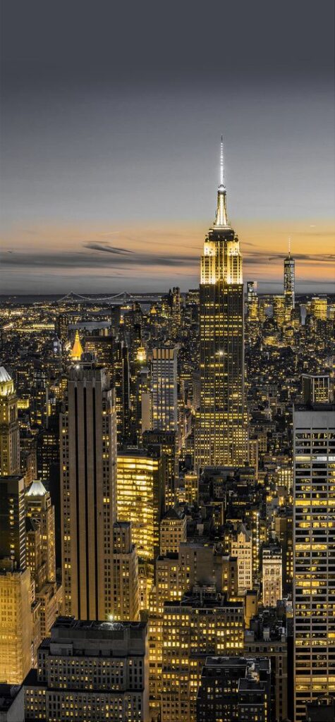 New York City skyline at sunset featuring the illuminated Empire State Building.