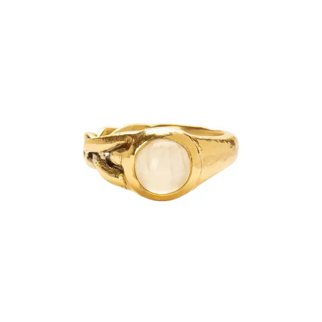 Gold ring with intricate design and a large, round gemstone centerpiece on a white background.