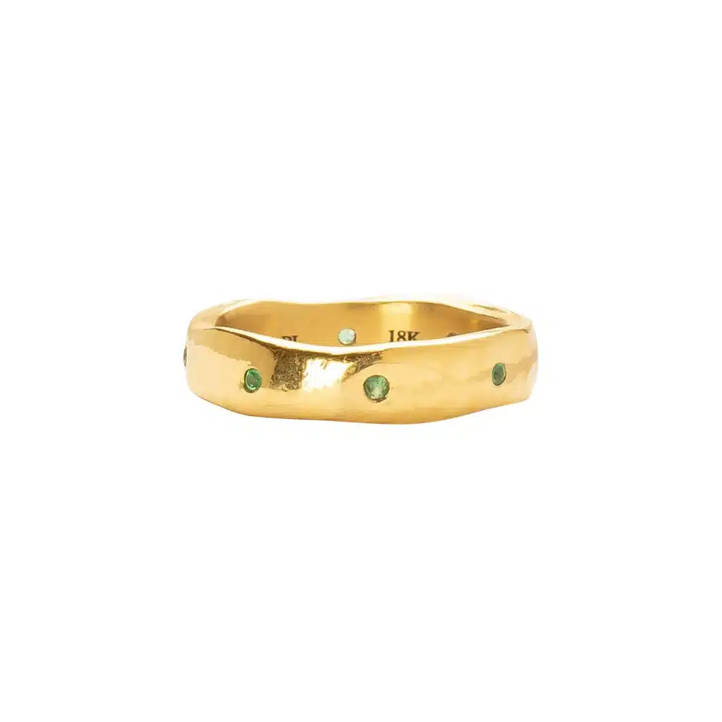 Gold ring with green gemstones, textured surface, and elegant design. Perfect for adding a touch of luxury.