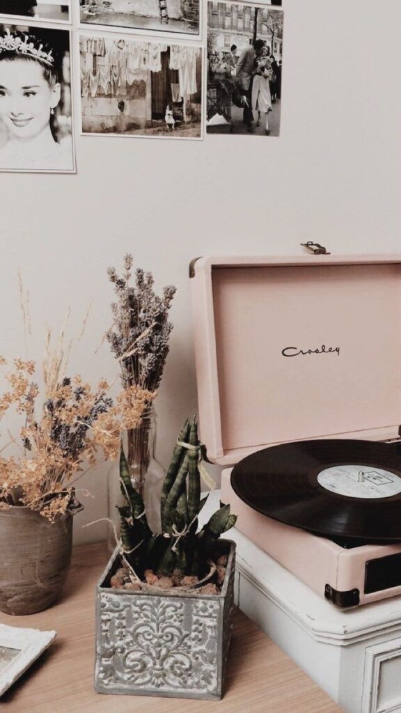 Pinterest Vintage record player on table with decorative plants and black-and-white photos on wall. Cozy, retro ambiance. | Sky Rye Design Vintage record player on table with decorative plants and black-and-white photos on wall. Cozy, retro ambiance. iPhone wallpaper