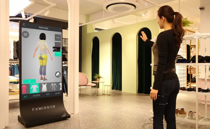 Woman using a virtual fitting room mirror in a clothing store.