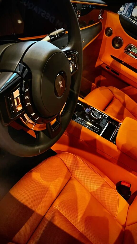 Luxurious car interior with orange leather seats and a sleek steering wheel, capturing elegance and style.