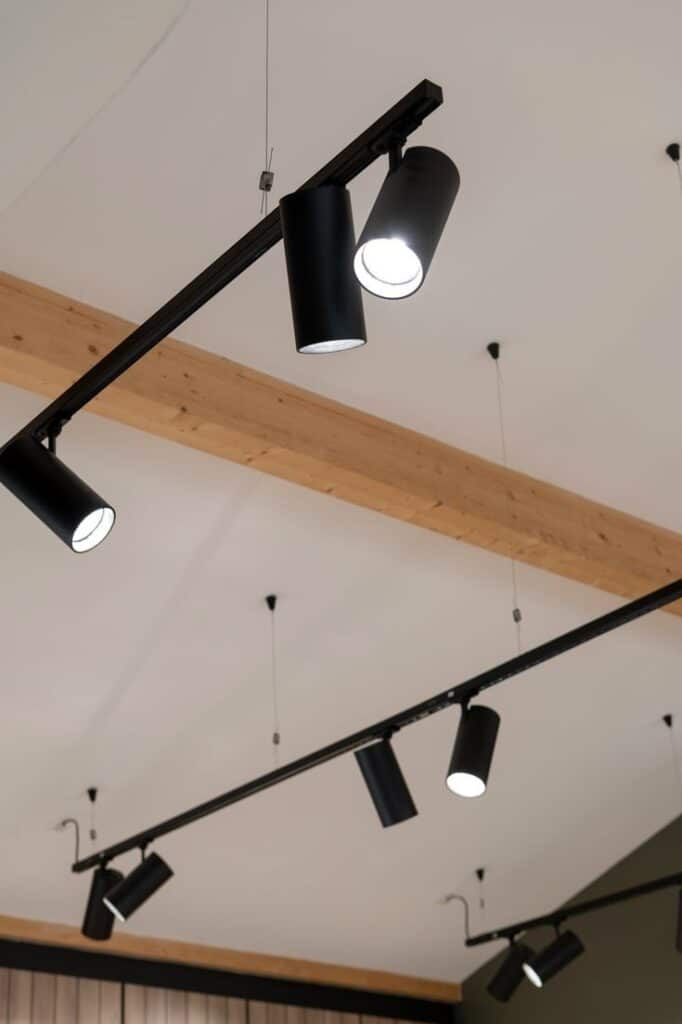 Modern black ceiling track lights on a wooden beam, enhancing interior lighting design.