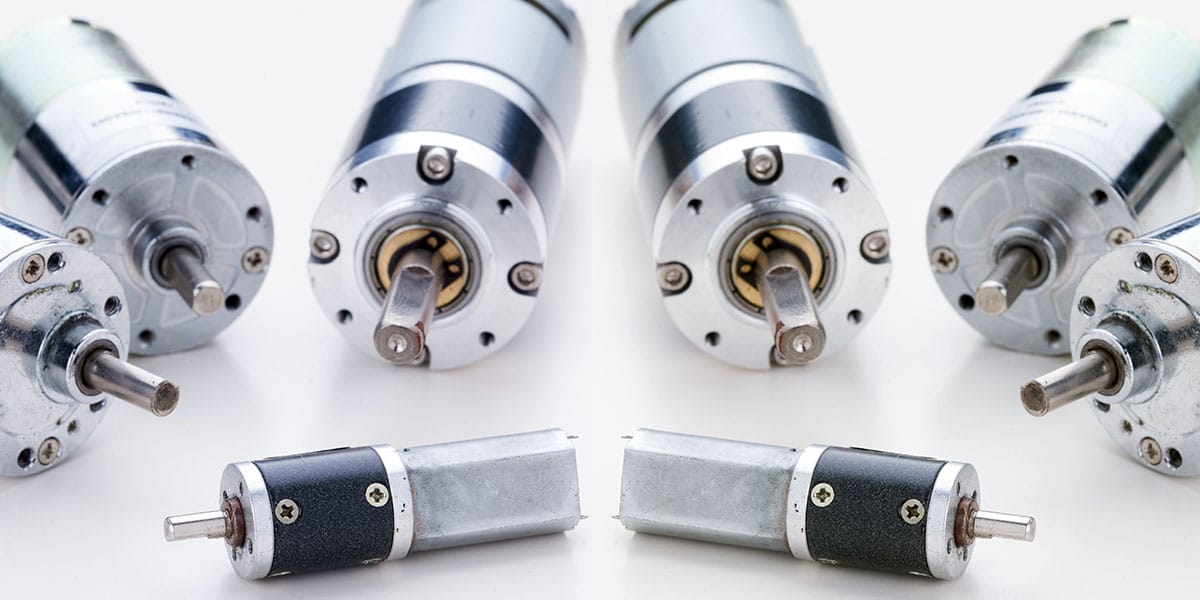 Close-up of several brushed DC motors arranged on a white background.