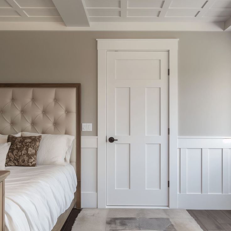 Modern bedroom interior with tufted headboard, neutral tones, and white paneled door. Cozy and elegant design.
