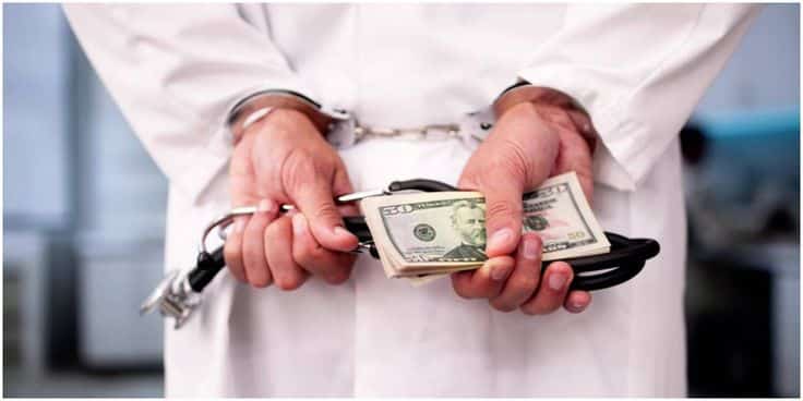 Doctor in handcuffs holding cash and stethoscope, symbolizing medical fraud or corruption.