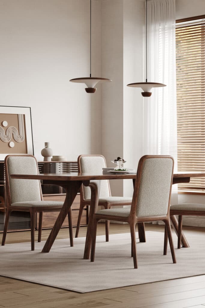 Modern dining room with wooden furniture, fabric chairs, pendant lights, artwork, and bright natural lighting.