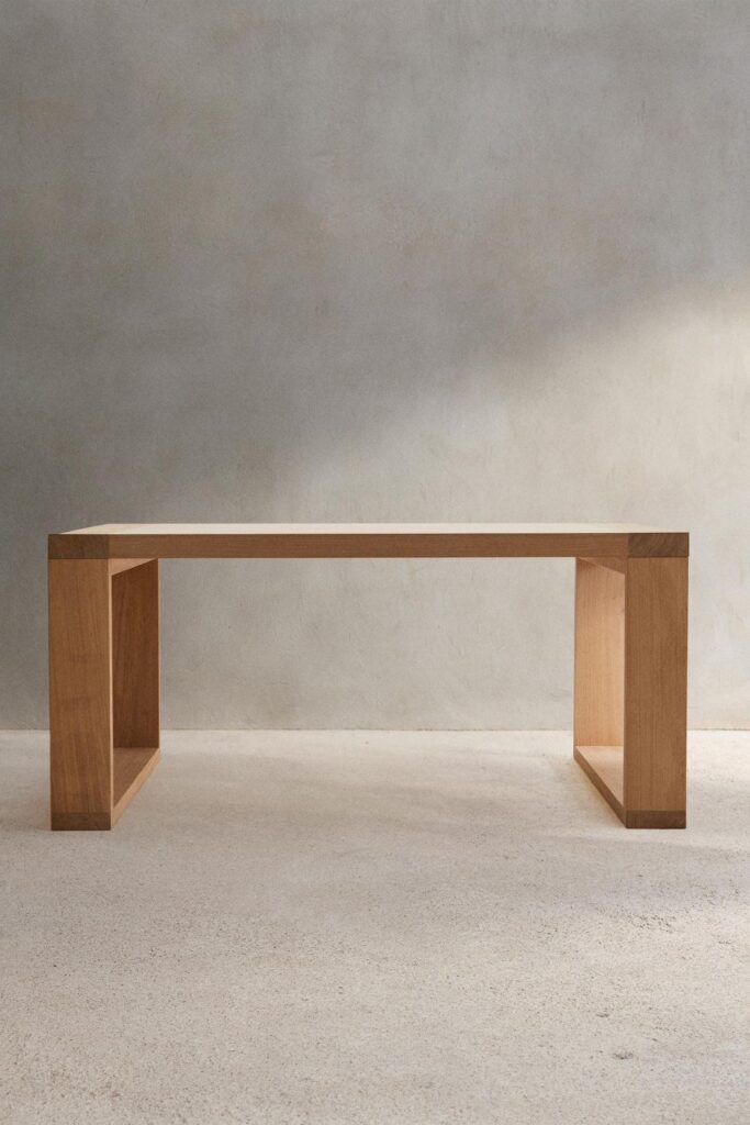 Minimalist wooden bench against a plain wall, showcasing modern design and simplicity in furniture.