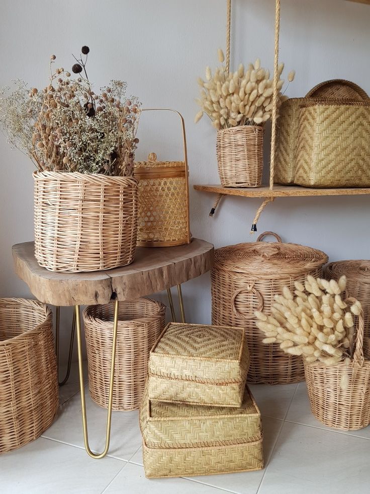 Woven baskets and dried flowers on a wooden table, highlighting rustic and natural home decor elements.